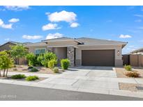 Charming single-story home with stone accents, a two-car garage, and manicured landscaping at 2027 W Sleepy Ranch Rd, Phoenix, AZ 85085