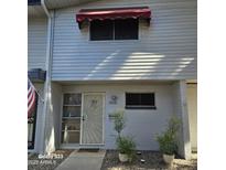 Well-maintained townhouse with attractive landscaping and a red awning at 2545 W Rose Ln # A-2, Phoenix, AZ 85017