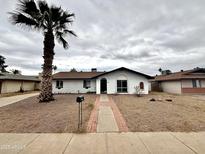 Single story home exterior with brick walkway and palm tree at 3841 W Cholla St, Phoenix, AZ 85029