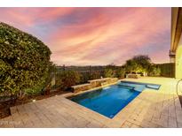 Inviting rectangular pool with a waterfall feature in the backyard at 1175 E Copper Holw, Queen Creek, AZ 85140