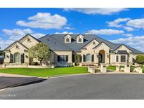 Beautiful single-story home featuring an arched entryway, lush landscaping, and a pristine lawn at 1233 E Salado Cir, Mesa, AZ 85203