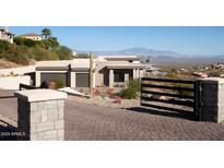 Modern home with desert landscaping and a brick driveway leading up to a two-car garage at 15436 E Golden Eagle Blvd, Fountain Hills, AZ 85268