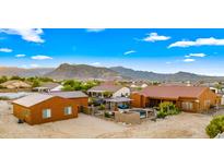 Aerial view of a house with a pool and large backyard, mountain views in the background at 19711 W Georgia Ave, Litchfield Park, AZ 85340