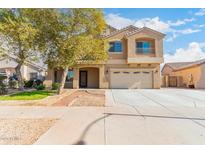 Two-story house with tan exterior, landscaped yard, and a two-car garage at 2315 S 173Rd Dr, Goodyear, AZ 85338
