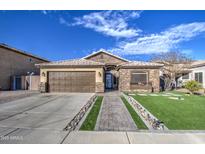 Single-story home with stone accents, landscaped yard, and a two-car garage at 7318 W Jones Ave, Phoenix, AZ 85043