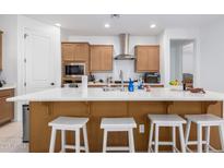 Island kitchen with light wood cabinets, stainless steel appliances, and white countertops at 12105 W Luxton Ln, Avondale, AZ 85323