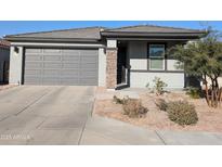 One-story home with gray exterior, two-car garage, and desert landscaping at 24550 W Mohave St, Buckeye, AZ 85326