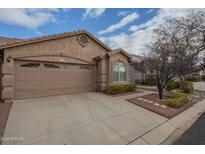 Tan two-car garage home with landscaping and a paved driveway at 6610 E University Dr # 157, Mesa, AZ 85205