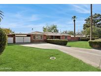 Brick ranch home with a spacious lawn, driveway, and gated entry at 1435 E Rose Ln, Phoenix, AZ 85014