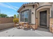 Inviting front exterior with a patio seating area and dark gray front door at 17403 W Eagle Ct, Goodyear, AZ 85338