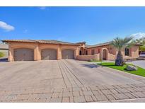 Three-car garage, Spanish-style home with landscaped grounds at 351 N Cloverfield Cir, Litchfield Park, AZ 85340