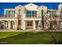 Two-story townhome with Spanish-style architecture,balcony, and landscaped lawn at 4047 E Erie St # 102, Gilbert, AZ 85295