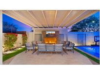 Outdoor living space with fireplace, seating, and a sparkling pool at 4106 S Helios --, Mesa, AZ 85212