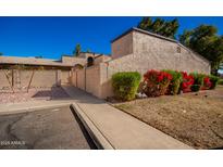 Condo building exterior with walkway and red flowers at 4731 W Continental Dr, Glendale, AZ 85308