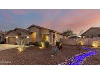Well-maintained house with desert landscaping and accent lighting at 18645 W Mcneil St, Goodyear, AZ 85338
