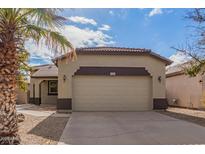 Tan house with a two-car garage and palm trees at 44783 W Alamendras St, Maricopa, AZ 85139
