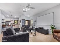 Open living room with adjacent kitchen and a large screen at 44783 W Alamendras St, Maricopa, AZ 85139
