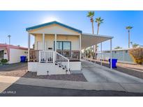 Single-wide manufactured home with carport, steps, and covered porch at 5201 W Camelback Rd # F316, Phoenix, AZ 85031