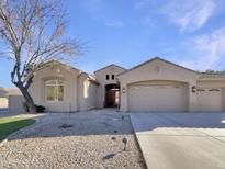 Beige house with three-car garage and landscaped front yard at 741 N Tower Pl, Chandler, AZ 85225