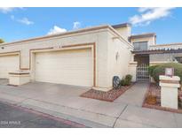 Tan two-story condo building with attached garage and gated entryway at 10836 N 29Th Ave, Phoenix, AZ 85029