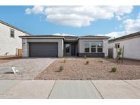 Charming single-story home with a desert-friendly rock garden and a two-car garage at 11441 E Utah Ave, Mesa, AZ 85212