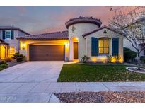 Charming home featuring a two-car garage, well-manicured lawn, and unique architectural details like a turret entrance at 15432 W Corrine Dr, Surprise, AZ 85379