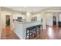 Bright kitchen featuring white cabinetry, stainless steel appliances and breakfast bar with seating at 433 N Neuman Pl, Chandler, AZ 85225