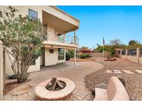 Spacious backyard featuring a brick patio, fire pit, seating, and a well-manicured garden with an American flag at 5010 E Mesquite Wood Ct, Phoenix, AZ 85044