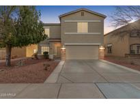 Two-story house with a beige exterior, stone accents, and a two-car garage at 13257 W Watson Ln, Surprise, AZ 85379