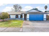 Single-story home with a blue garage door and well-manicured lawn at 4749 E Evergreen St, Mesa, AZ 85205