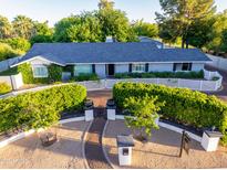 Charming single-story home with a manicured front yard, white picket fence, and lush greenery at 5249 E Thunderbird Rd, Scottsdale, AZ 85254