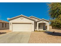 Charming single-story home with a well-manicured front yard and a two-car garage at 7420 W Glass Ln, Laveen, AZ 85339