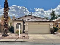 Charming single-story home featuring a well-maintained front yard and two-car garage at 9131 W Boca Raton Rd, Peoria, AZ 85381