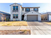 Two-story home with a gray-tone exterior, a large garage, and a well-manicured lawn at 9625 E Spiral Ave, Mesa, AZ 85212