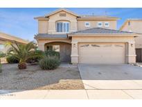 Two-story house with a tan exterior, two-car garage, and desert landscaping at 11625 W Jackson St, Avondale, AZ 85323