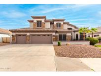 Two-story house with three-car garage, stone accents, and landscaped yard at 1451 E Ivanhoe St, Gilbert, AZ 85295