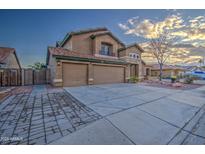 Two-story house with three-car garage and landscaped front yard at 15727 W Rimrock St, Surprise, AZ 85374