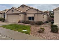 Tan stucco house with tile roof, two-car garage, and landscaped yard at 17065 N Silver Path, Surprise, AZ 85374