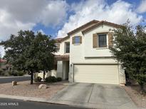 Two-story house with a beige exterior, two-car garage, and landscaping at 2715 S Sailors Way, Gilbert, AZ 85295