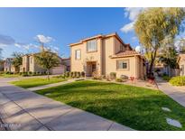 Two-story tan house with a landscaped lawn and walkway at 41705 N Globe Ct, Phoenix, AZ 85086