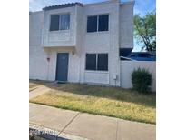 Two-story stucco condo with a gray door and small front yard at 5233 N 42Nd Dr, Phoenix, AZ 85019