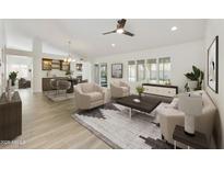 Open-concept living room with neutral decor, tile floors, and plenty of natural light at 9230 N 104Th Pl, Scottsdale, AZ 85258