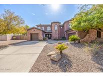 Stunning two-story home with stone accents and a three-car garage at 4543 S Roy Rogers Way, Gilbert, AZ 85297