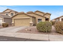 Tan two-story house with a two-car garage and well-maintained landscaping at 11608 W Oglesby Ave, Youngtown, AZ 85363