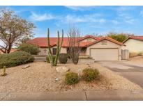 Tan house with red tile roof, desert landscaping, and a two-car garage at 16420 N Scorpion Dr, Fountain Hills, AZ 85268