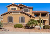 Two-story house with a large front yard, tan exterior, and a three-car garage at 17584 W Andora St, Surprise, AZ 85388