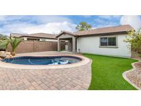 Kidney shaped pool with brick coping and artificial turf at 21362 E Puesta Del Sol Rd, Queen Creek, AZ 85142