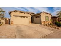 Charming home featuring a three-car garage and manicured landscaping on a sunny day at 23933 N 167Th Ln, Surprise, AZ 85387