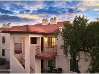 Two-story stucco building with red tile roofs, balconies, and a tree at 455 S Delaware Dr # 154, Apache Junction, AZ 85120