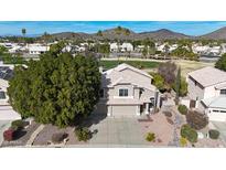 Aerial view of two story house with a desert landscape, golf course, and mountain background at 6282 W Rose Garden Ln, Glendale, AZ 85308